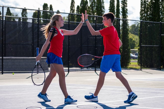 St. Clair freshman Hadley Schwarz, left, high-fives her brother Quinn after a point during a tennis match against Cranbrook Monday, Sept. 23, 2019, at St. Clair High School. The brother-sister duo are St. Clair's No. 1 ranked doubles team.