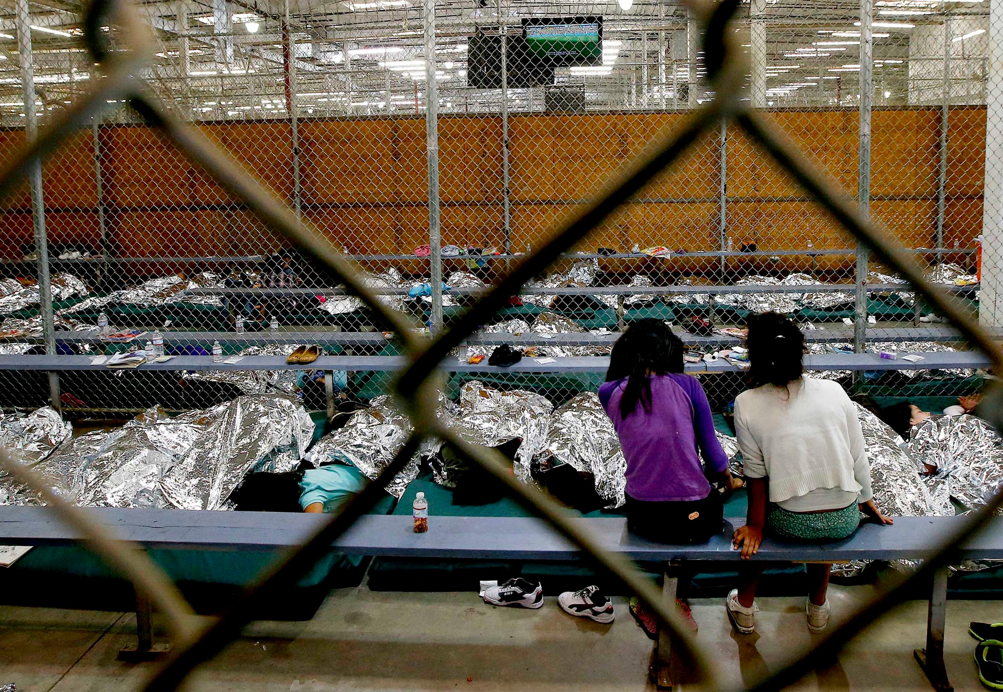 NOGALES, Ariz. Ð In June 2014, two young girls watch a World Cup soccer match on a television from their holding area where hundreds of mostly Central American immigrant children are being processed and held at the U.S. Customs and Border Protection Nogales Placement Center.