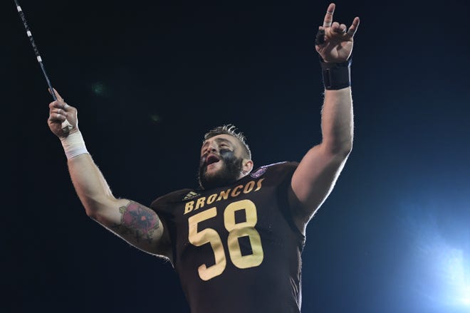 Western Michigan University senior defensive end Tony Balabani leads the band in the school fight song following the Broncos' 48-13 win over Monmouth on Saturday, Aug. 31, 2019. Balabani was born in Kosovo, but fled the war-torn country with his family in 1999.