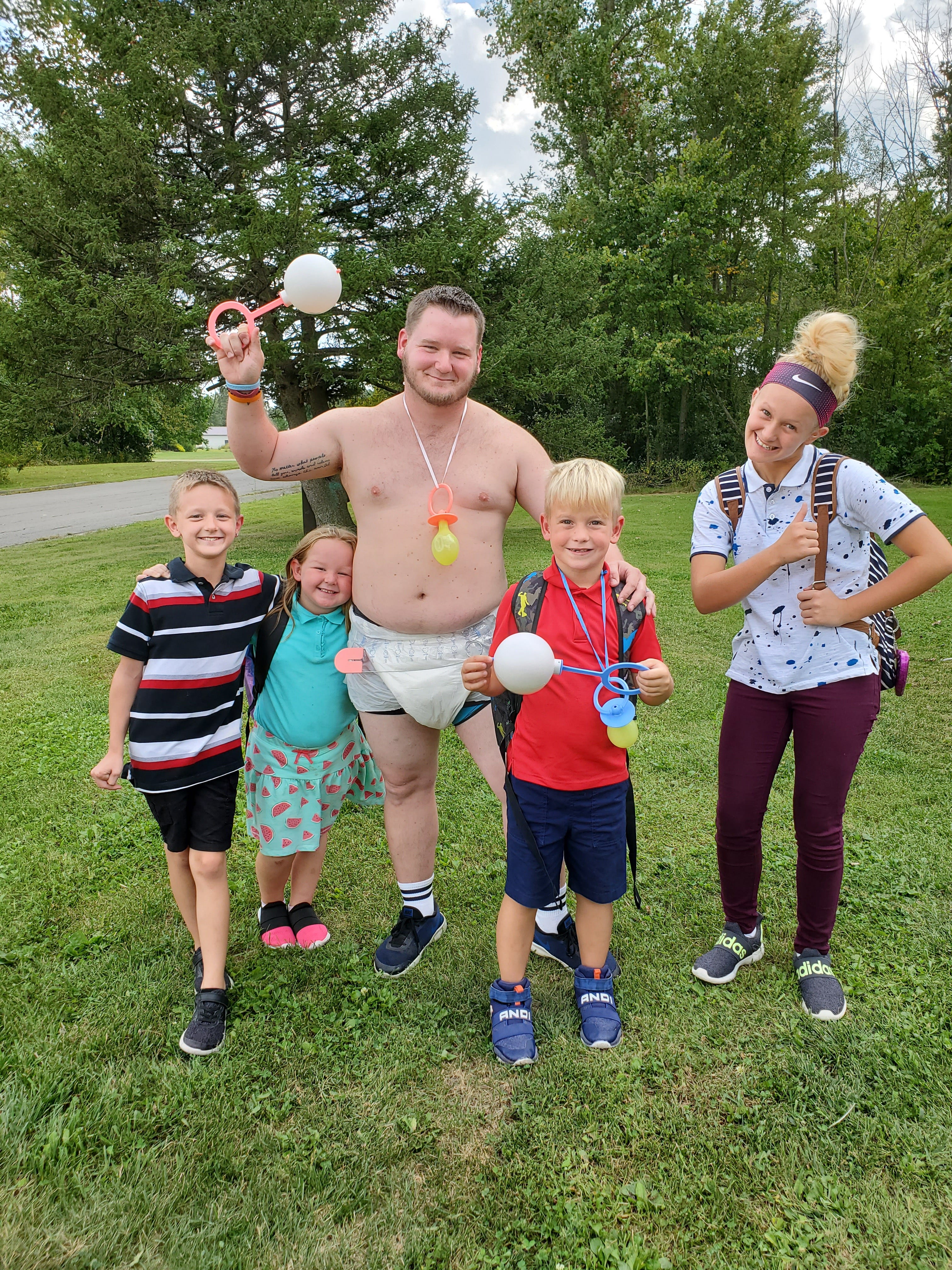 Every Monday afternoon, Crestline dad B Lavene greets the school bus wearing a different silly costume. From left are Billy, Karter, B, Dylan and Addisyn.