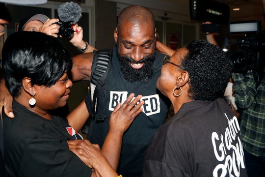 Wendell Brown hugs relatives after his arrival at the Detroit Metropolitan Airport, Wednesday, Sept. 25, 2019, in Romulus, Mich. Brown returned from China where he was imprisoned for his involvement in a bar fight. Brown, a native of Detroit had been teaching English and American football in southwest China when he was arrested in September 2016 and charged with intentional assault.