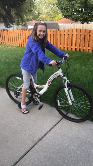 Jenna Kofoed, 11, of South Milwaukee likes her new bicycle which was gifted to her by Cudahy resident Michelle McCormick after Jenna's bike was stolen.