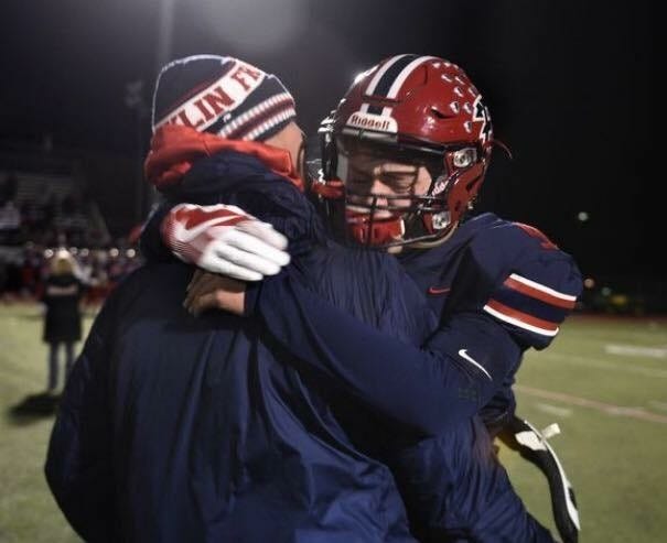 Livonia Franklin quarterback Jake Kelbert hugs his father and head coach Chris Kelbert after a game.