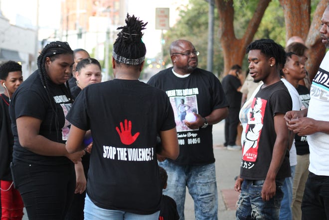 Andrea Jones, the cousin of murder victim Ty'Neisha Sade Briggs, wears a T-shirt with "Stop The Violence!" on the back. Jones spoke Wednesday at a vigil to remember victims, saying