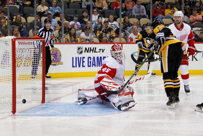 Penguins' Bryan Rust, right, scores on Red Wings goaltender Jonathan Bernier during the second period.