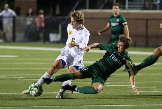Sulli Meyer tries to edge past Jeremy Mason's reach as the Tigers and Shamrocks battle Wednesday, Sept. 25, 2019 in Louisville, Ky. St. X soccer beat Trinity 1-0 scoring late in the second half.