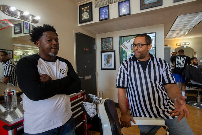 Kwabena Antoine Nixon, left, listens as his barber since 2004, Richard Armstead, talks about the importance of developing strong ties with clients at Gee's Clippers.