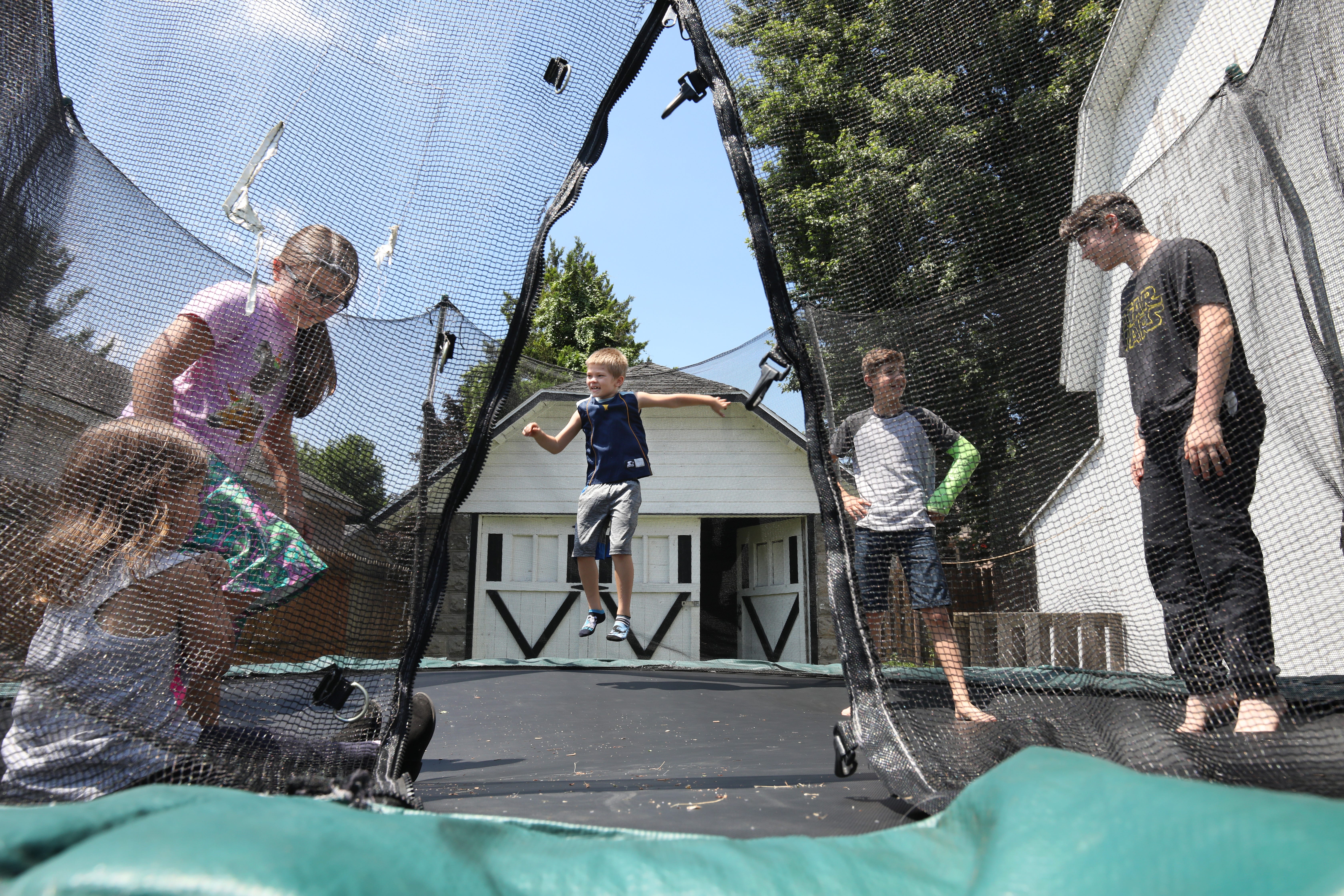 Bentley Niles, center, joins his sister Gabby, left, and his cousins as they play in the backyard where his father Josh Niles lived with girlfriend  Amber Washburn, Wednesday, July 3, 2019 in Sodus, NY.  Josh and Amber were murdered in the same back yard by Tim Dean, the boyfriend of the boy's mother, Charlene Childers.  