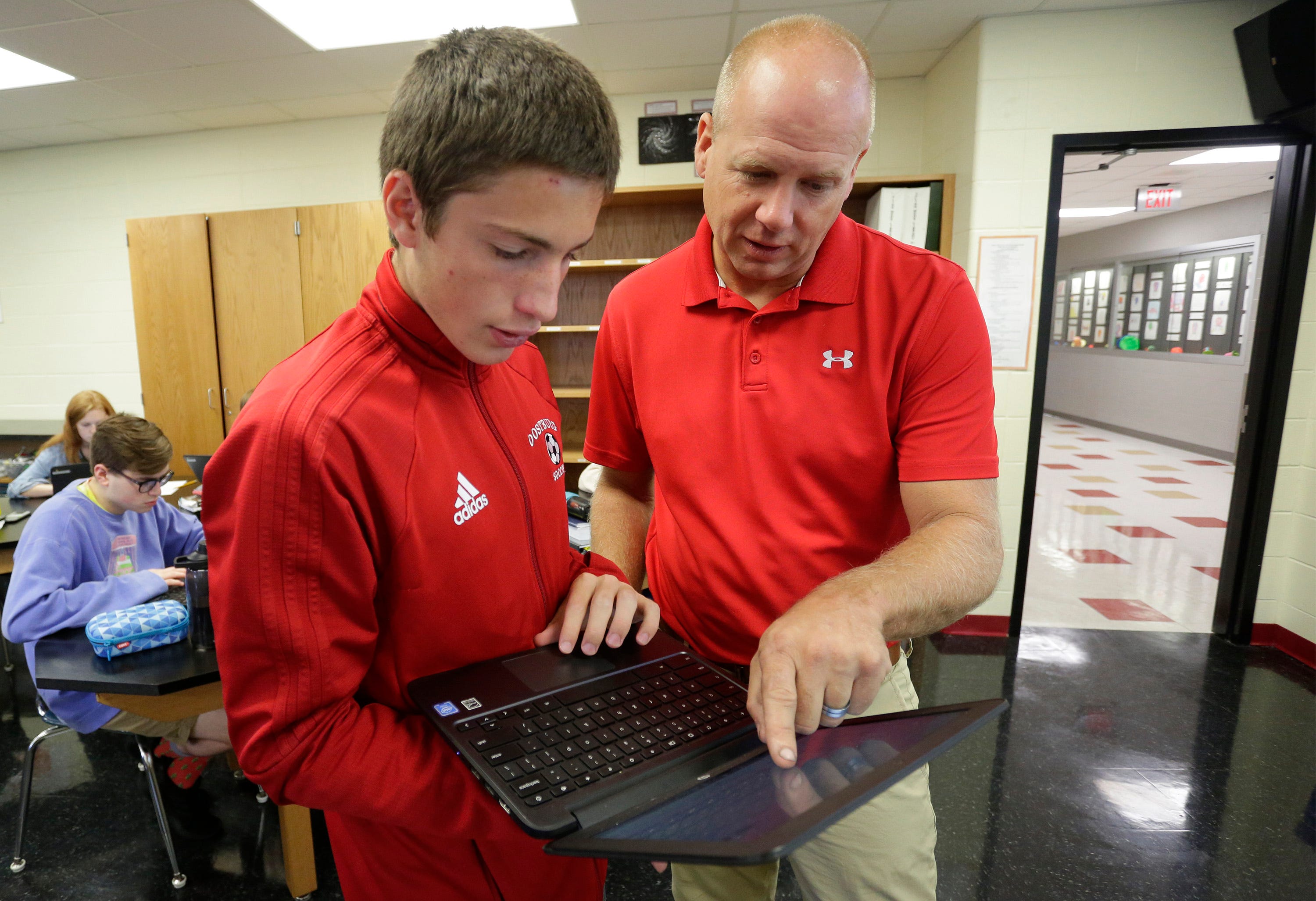 Oostburg High School junior Kyle Schinner listens as physics teacher Terry Hendrikse explains a spreadsheet used for an experiment, Wednesday, September 25, 2019, in Oostburg. Part of the district's turnaround efforts included incorporating hands-on, experiment-based learning earlier on in school.