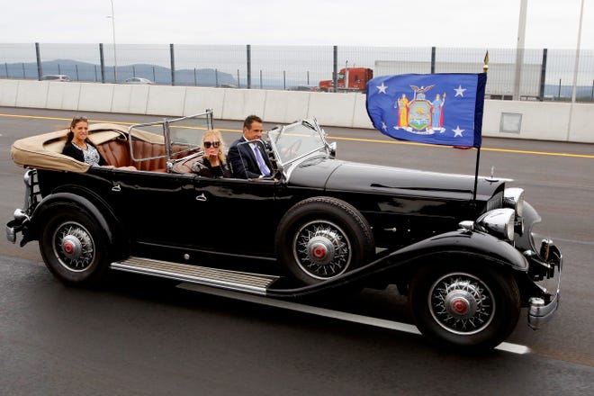 New York Gov. Andrew Cuomo drives a 1932 Packard as his girlfriend, TV chef Sandra Lee, blows a kiss as they cross the Gov. Mario M. Cuomo Bridge, Friday, Sept. 7, 2018, in Nyack, N.Y. Cuomo officially opened the second span of the new Hudson River Bridge that bears his father's name. (AP Photo/Mark Lennihan)
