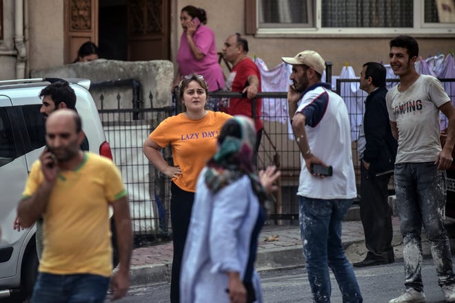 People stand on the streets after evacuating their homes, following an earthquake in Istanbul, Thursday, Sept. 26, 2019. Turkey's emergency authority says a 5.8 magnitude earthquake has shaken Istanbul with no immediate damage reported.