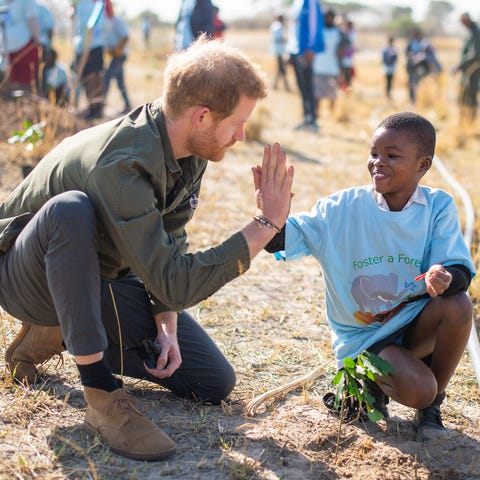 Prince Harry high-fives a child as he joins school