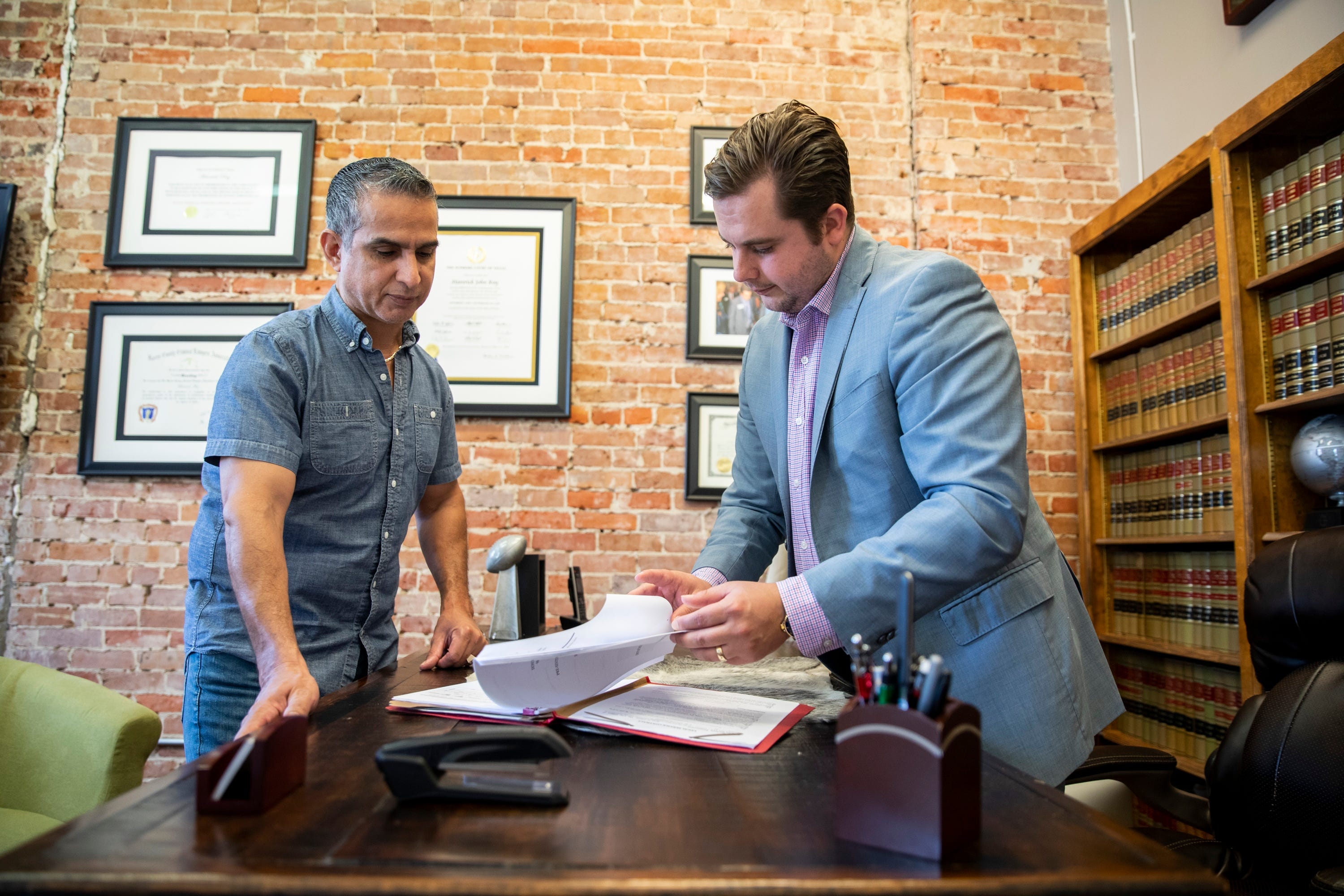 Revat Vara, left, who spent 11 years in prison for a wrongful DWI conviction, speaks with his lawyer Maverick Ray, right, in Houston. Vara studied the law in prison as he worked with his legal team to win his release in 2017.