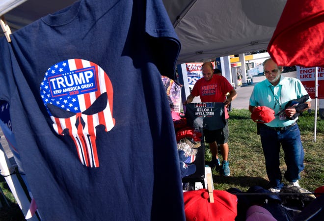 Brian Ayotte examines a red Donald Trump cap after trying on a Trump shirt Friday. There are three Trump Shop tents in Abilene until Tuesday, including this one at South First and Leggett streets. The other two are at the intersection of Barrow and South 27th streets and at 4424 Buffalo Gap Road.