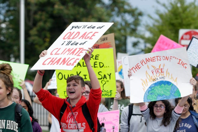 Students hold up signs as they walk from West Lafayette Jr./Sr. High School to the city library during climate change strike, Friday, Sept. 27, 2019, in West Lafayette. About 300 students and community members marched from West Lafayette Jr./Sr. High School to the West Lafayette library and then to Happy Hollow School calling for climate change action.