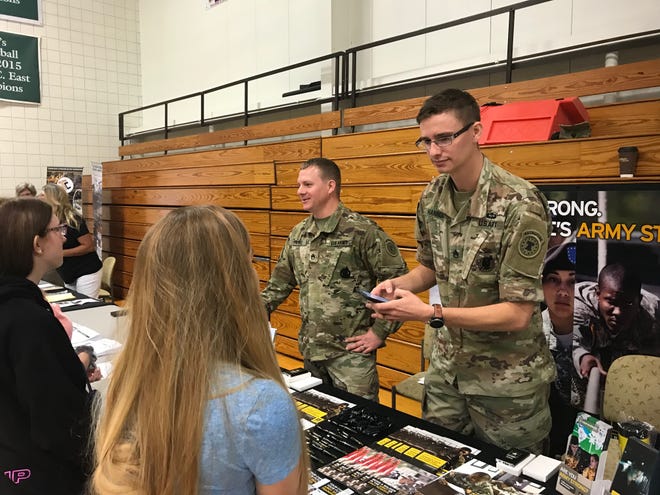 U.S. Army Staff Sgt. Alex Parke (left) and Sgt. Kyle Hannum talk to visitors Friday at the Ohio Means Jobs/Fairfield County Job and Family Services job fair at Ohio University Lancaster.