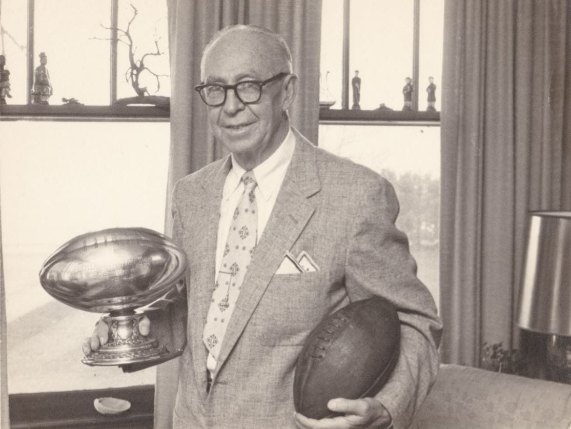 Leo Lyons started as a player and ended up doing almost everything, including owning, the Rochester Jeffersons. Lyons is holding the 1916 New York state amateur championship trophy and a football from that season.