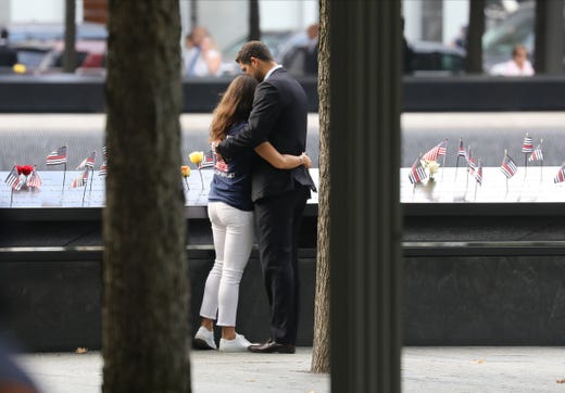 A couple embrace at the pool by the names of the South Tower in New York City on Sept. 11, 2019, during the 18th anniversary of the attacks on the World Trade Center, the Pentagon and Shanksville, Pa.