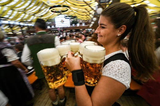 A waitress carries mugs of beer in the Paulaner Winzerer Faehndl tent during the opening day of the 186th Oktoberfest beer festival on the Theresienwiese in Munich, Germany, Sept.21, 2019. The Munich Beer Festival is the world's largest traditional beer festival.