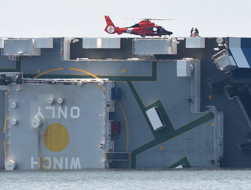 Members of the U.S. Coast Guard unload supplies from a Coast Guard helicopter from the side of the cargo ship Golden Ray, Sept. 9, 2019, after their vessel overturned while leaving the Port of Brunswick, Ga., early Sunday morning. The Coast Guard were attempting to rescue 4 crew members trapped on the ship.