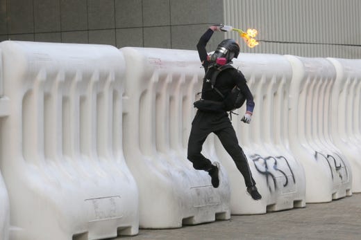 A protester throws a Molotov cocktail during an anti-government rally in Hong Kong, China, Sept. 15, 2019. Protesters called on the British Government to take action against China for not honoring the Sino-British Joint Declaration. Hong Kong has entered its fourth month of mass protests triggered by a now-suspended extradition bill to mainland China. The protests have turned into a wider pro-democracy movement.