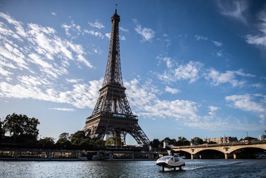An Electric boat, the Sea Bubbles, aka "flying taxi" cruises on the river Seine with the Eiffel Tower in background during a test in Paris, on Sept. 18, 2019.