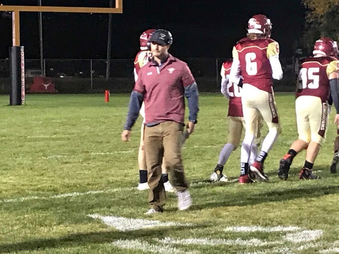 Fort Benton head coach Jory Thompson, center, leaves his team's huddle after a timeout in the first half of his team's 46-35 win over Great Falls Central Friday night at Lenington Memorial Field.