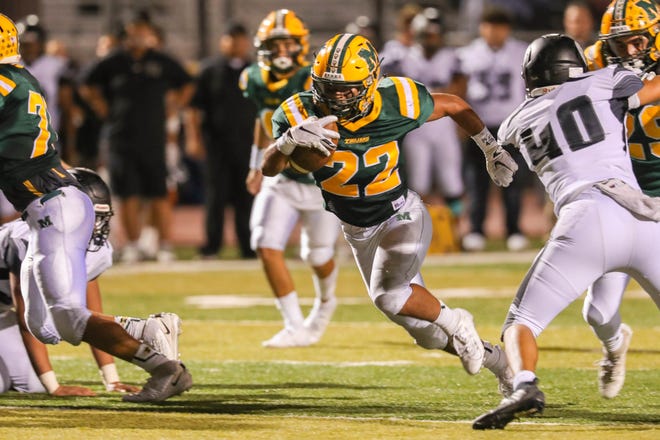 Senior running back Mathew Riley (22) runs the ball as the Mayfield Trojans face off against the Oñate Knights at the Field of Dreams in Las Cruces on Friday, Sept. 27, 2019.