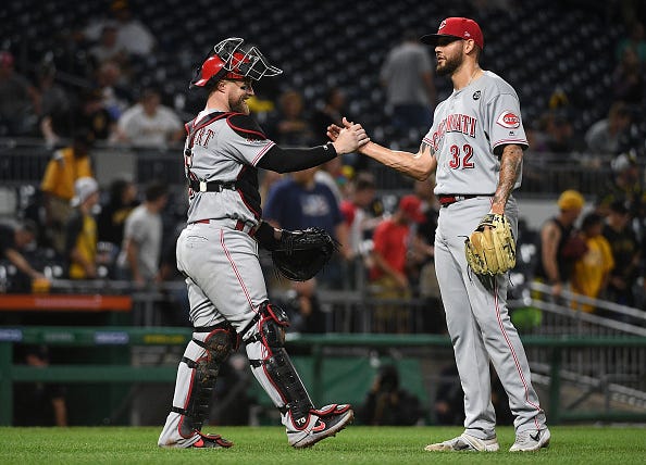 R.J. Alaniz #32 of the Cincinnati Reds celebrates with Tucker Barnhart #16 after the final out in a 4-2 win over the Pittsburgh Pirates in twelve innings at PNC Park on September 28, 2019 in Pittsburgh, Pennsylvania.