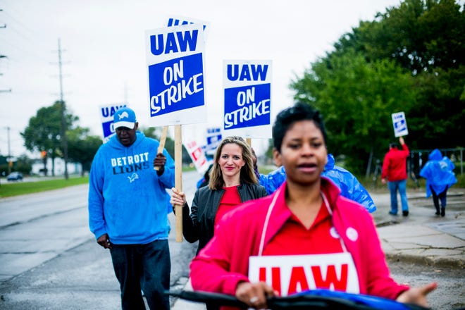 Michigan Secretary of State Jocelyn Benson, center, walks the picket line outside the General Motors Co.'s Warren Transmission Operations plant during lengthening UAW strike against the automaker.