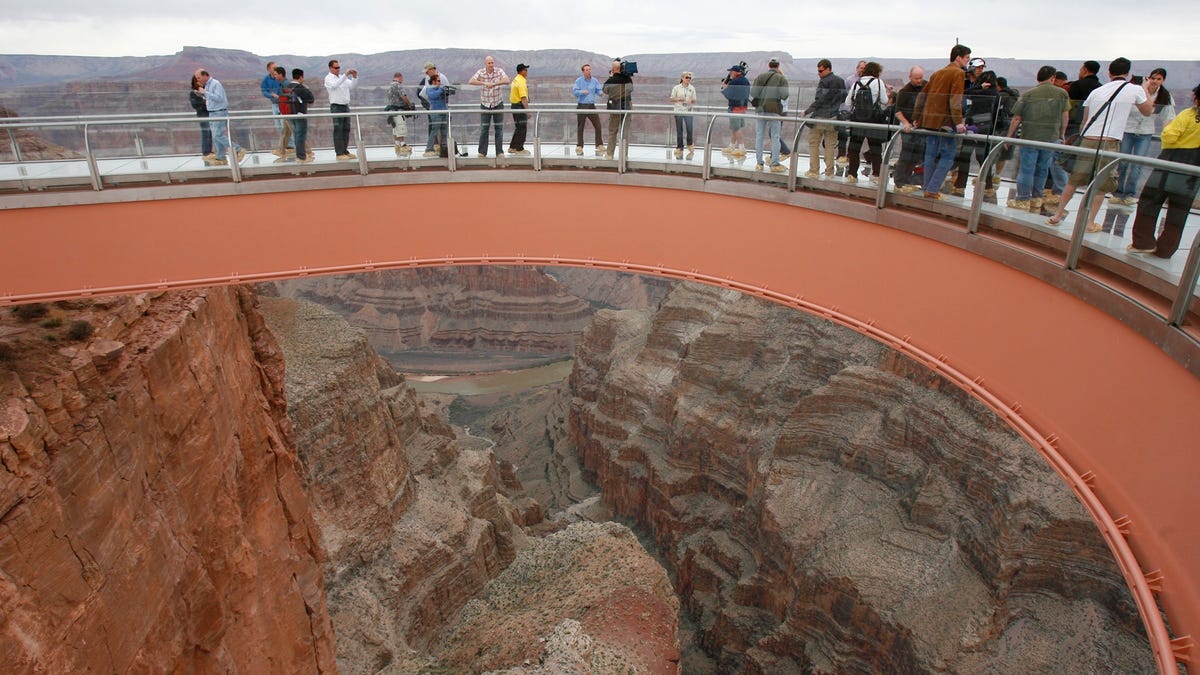 In this March 20, 2007, file photo, people walk on the Skywalk during the first walk event at the Grand Canyon on the Hualapai Indian Reservation at Grand Canyon West, Ariz. Authorities are trying to locate the body of a man who climbed over a safety barrier at the Grand Canyon Skywalk and apparently jumped to his death.