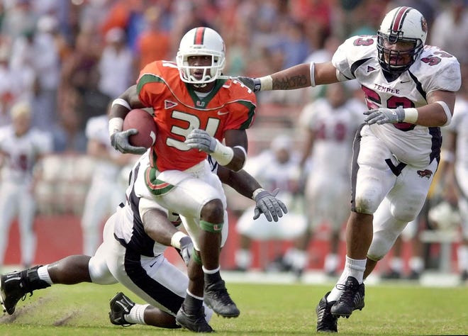 Miami's Phillip Buchanon (31) evades Temple defenders Yazid Jackson, back, and Anthony Nembhard (53) during a punt return that Buchanon ran back for a touchdown in the second half Saturday Nov. 3, 2001 at the Orange Bowl in Miami.