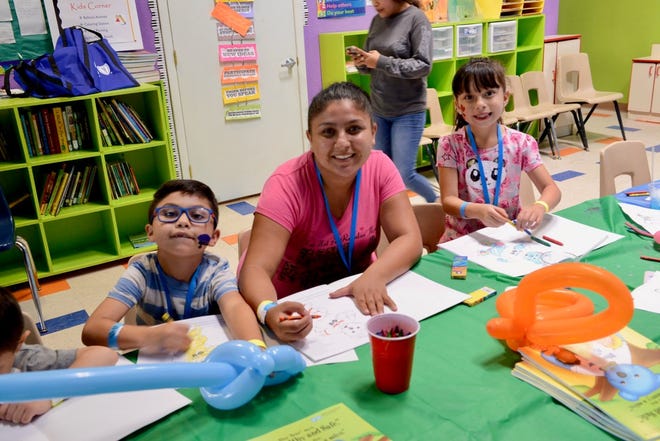A mother and her children enjoy the Kids’ Korner at the event at the Fiesta de Salud para Familias community health fair at New Mexico Family Services in Sunland Park in August 2019.