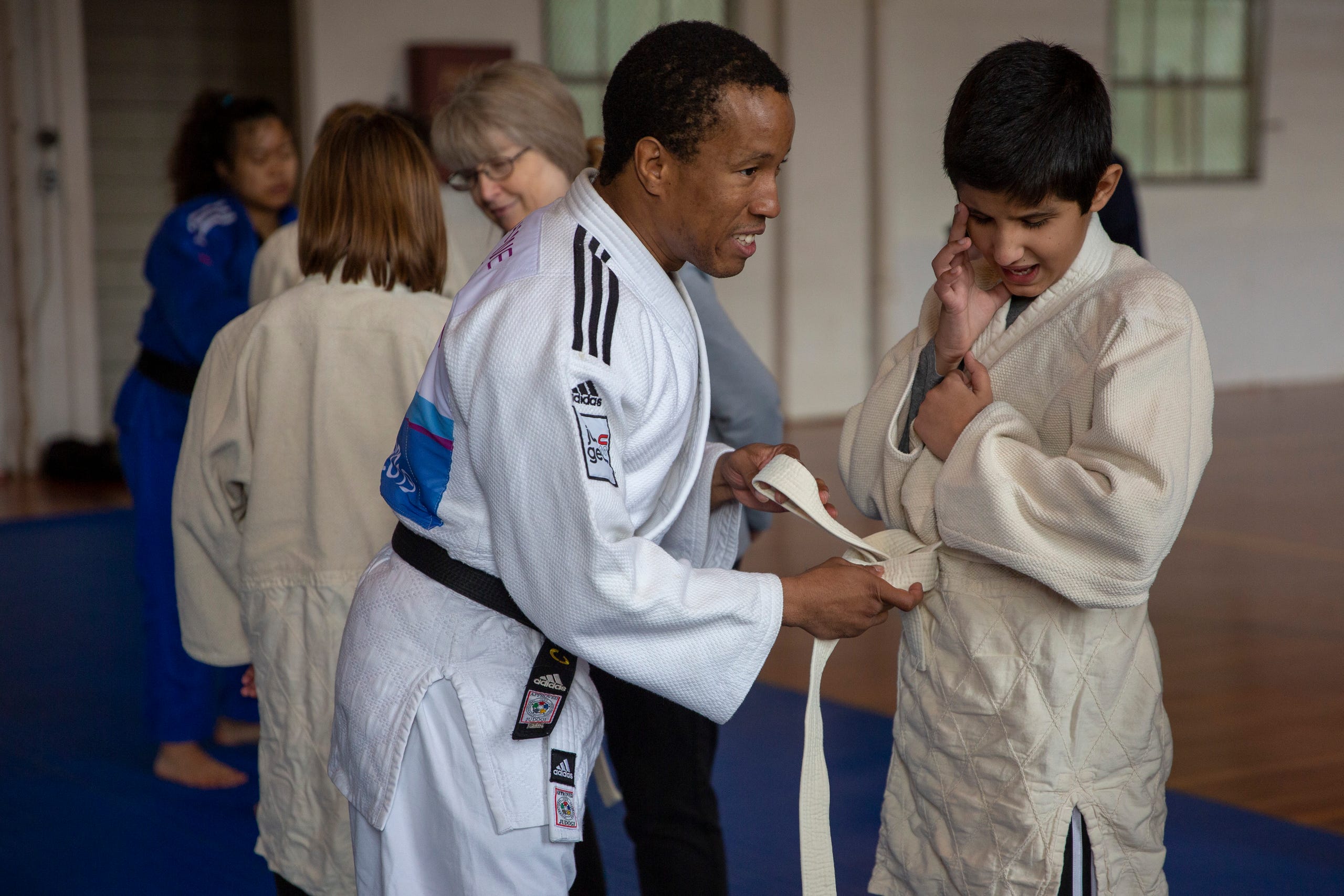 Instructor and Judo Paralympian Ron Hawthorne ties the robe of sixth-grader Saifullah Tahirkheli at the Oregon School for the Deaf in Salem, Oct. 4, 2019. NWABA, the Northwest Association for Blind Athletes, hosted a "Paralympic experience" for students with visual impairments in the state. After the Oregon School for the Blind closed in 2009, many visually impaired students and their families lost access to state-funded resources, like sports programs. The BVIS (Blind Visually Impaired Student) Fund gives programs like NWABA funds to enhance the lives of low vision/blind children across the state.