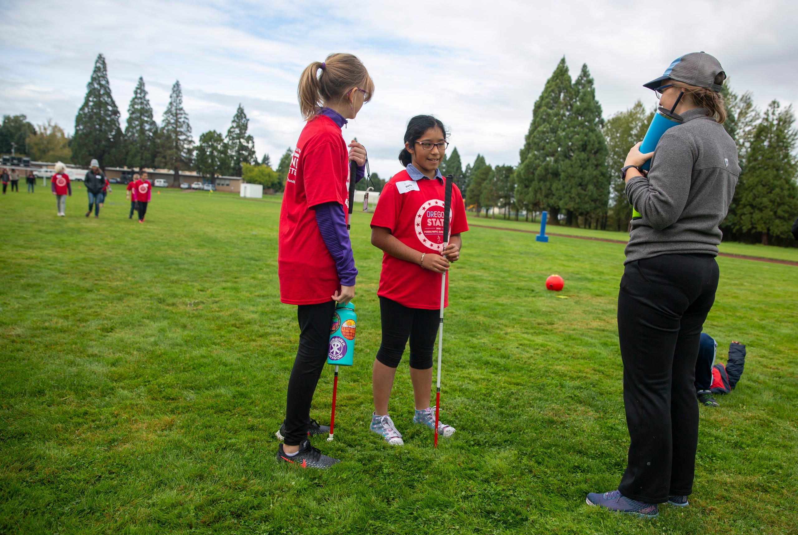 Ellen Shrout, in 7th grade, and Ruth Gongora, in 6th, talk to a beep kickball instructor at the Oregon School for the Deaf in Salem, Oct. 4, 2019. NWABA, the Northwest Association for Blind Athletes, hosted a "Paralympic experience" for students with visual impairments in the state. After the Oregon School for the Blind closed in 2009, many visually impaired students and their families lost access to state-funded resources, like sports programs. The BVIS (Blind Visually Impaired Student) Fund gives programs like NWABA funds to enhance the lives of low vision/blind children across the state.