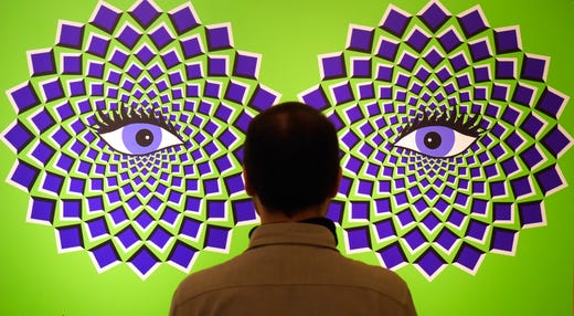 A man stands in front of a optical illusions picture during the press preview of the interactive experience exhibition 'Tricked! - The spectacular illusion exhibition' at Augustusburg castle in Augustusburg, Germany, Oct. 1, 2019. The show, which presents paintings by Mexican artist Yunuen Esparza, deals with the functioning of the eye, the laws of optics and the interconnection of the senses in the brain.