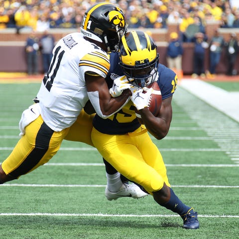 Michigan's Mike Sainristil fights for yardage whil