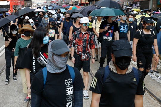 Masked protesters march in Hong Kong on Saturday, Oct. 5, 2019. All subway and trains services are closed in Hong Kong after another night of rampaging violence that a new ban on face masks failed to quell.