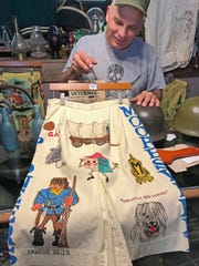 Mike Constable holds up a Mooresville senior cord skirt from 1969 at The Constable's Antiques store in Mooresville on Sept. 25, 2019.