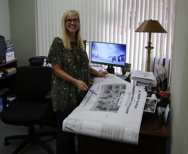 Karla Hamel, Carlsbad MainStreet director, shows off plans for a new gazebo set for the Eddy County Courthouse lawn.