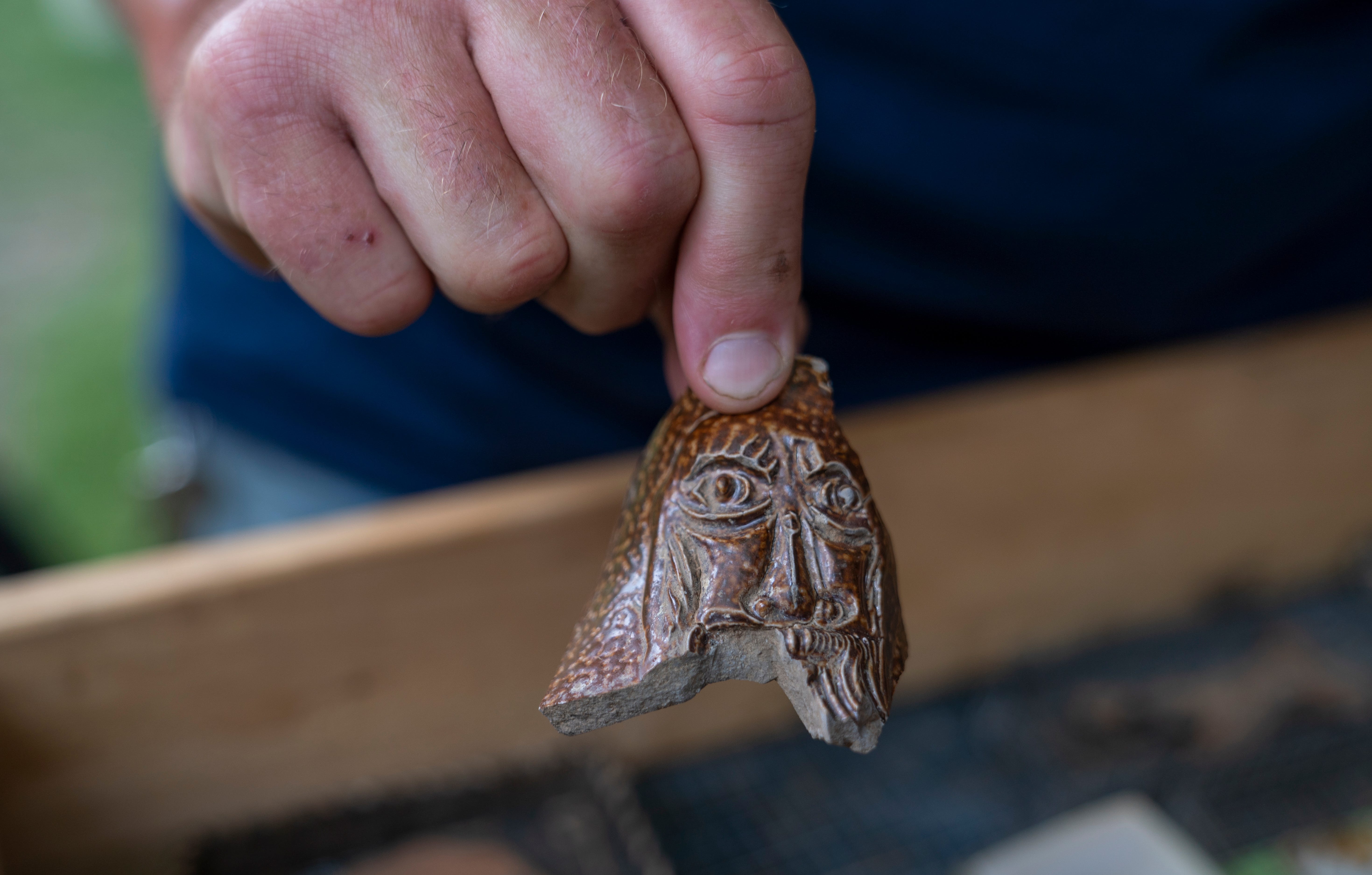 Lee McBee, staff archaeologist for the Jamestown Rediscovery Foundation, holds a fragment of a decorated pottery vessel found at the "Angela" dig site.