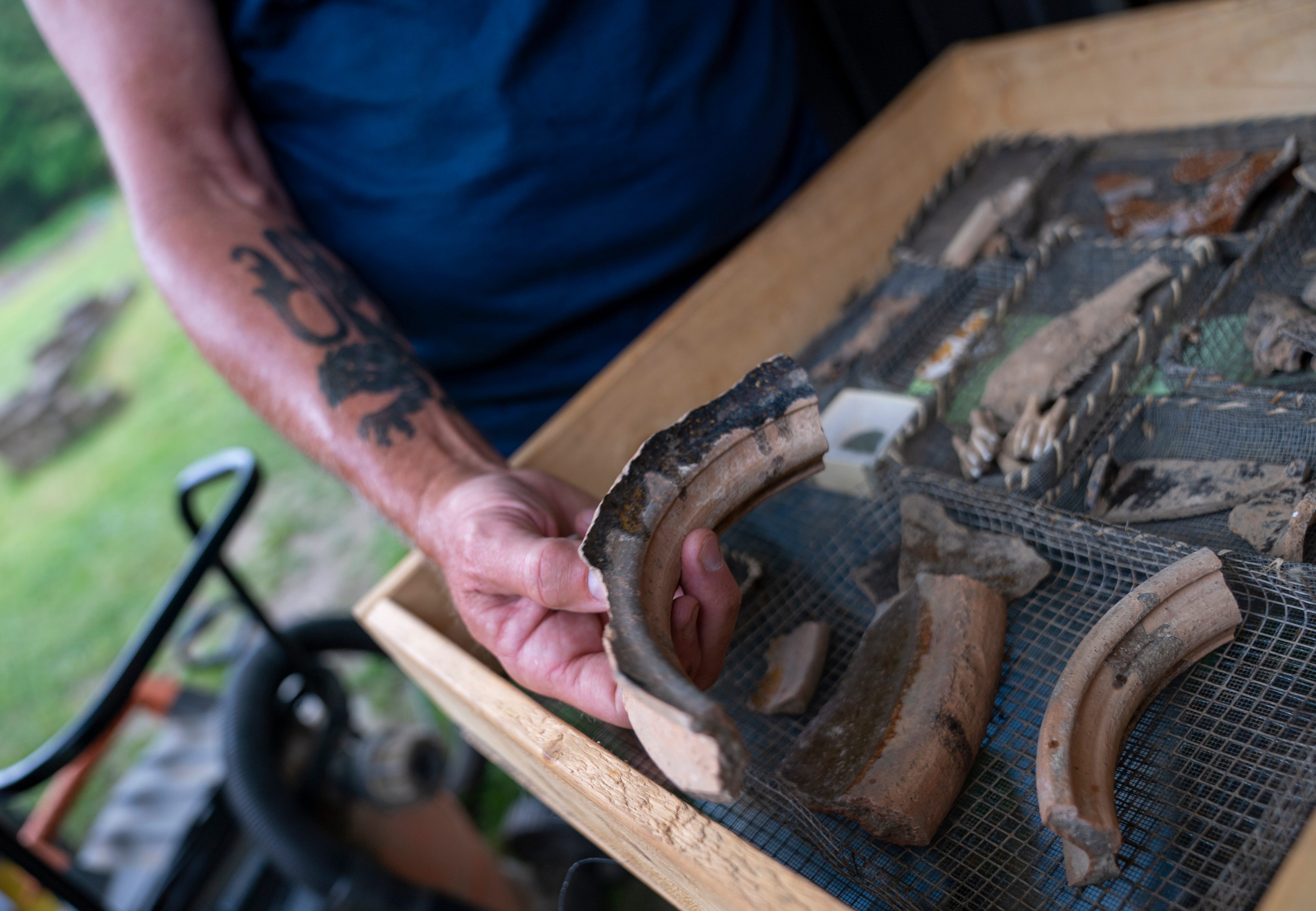 Lee McBee, staff archaeologist for the Jamestown Rediscovery Foundation, holds a piece of a serving vessel or pot found at the "Angela" dig site. Angela or other servants may have handled this sort of vessel.