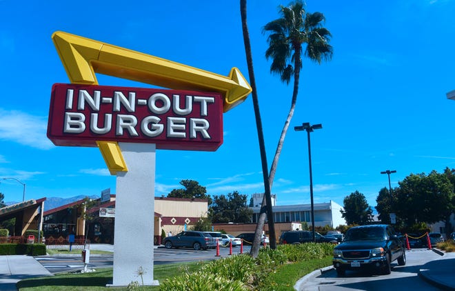 A driver pulls into the drive-thru lane at an In-N-Out Burger restaurant in Alhambra, California.