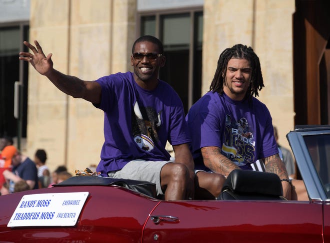 Aug 4, 2018; Canton, OH, USA; NFL former receiver Randy Moss (left) and presenter and son Thaddeus Moss acknowledge the crowd during the Pro Football Hall of Fame Grand Parade on Cleveland Avenue. Mandatory Credit: Kirby Lee-USA TODAY Sports