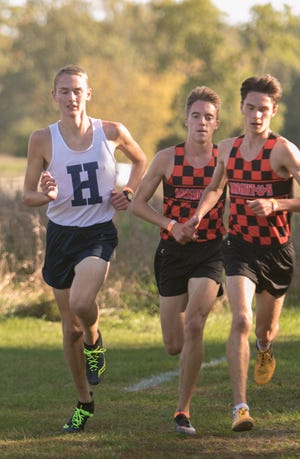 (From left) Hartland's Riley Hough races Brighton's Jack Spamer and Zach Stewart at Huron Meadows Metropark on Tuesday, Oct. 8, 2019.