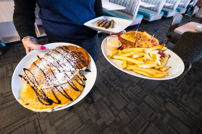 Chocolate chip pancakes, a reuben sandiwch with french fries and a plate of sausages are delivered to a table at Ocean Breeze in Marysville.