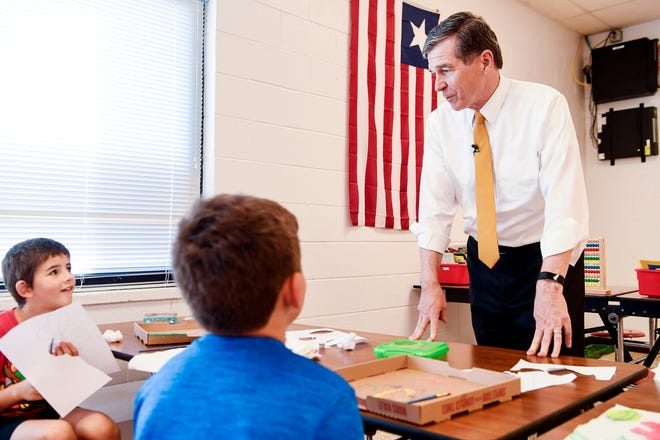 Gov. Roy Cooper talks to Merrill Rich, left, and Samuel Mace, both in third grade, as he visits North Buncombe Elementary October 10, 2019.