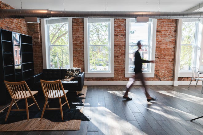 Bryce Eldridge walks through the living room of his brand new luxury apartment located above Paper City Coffee.