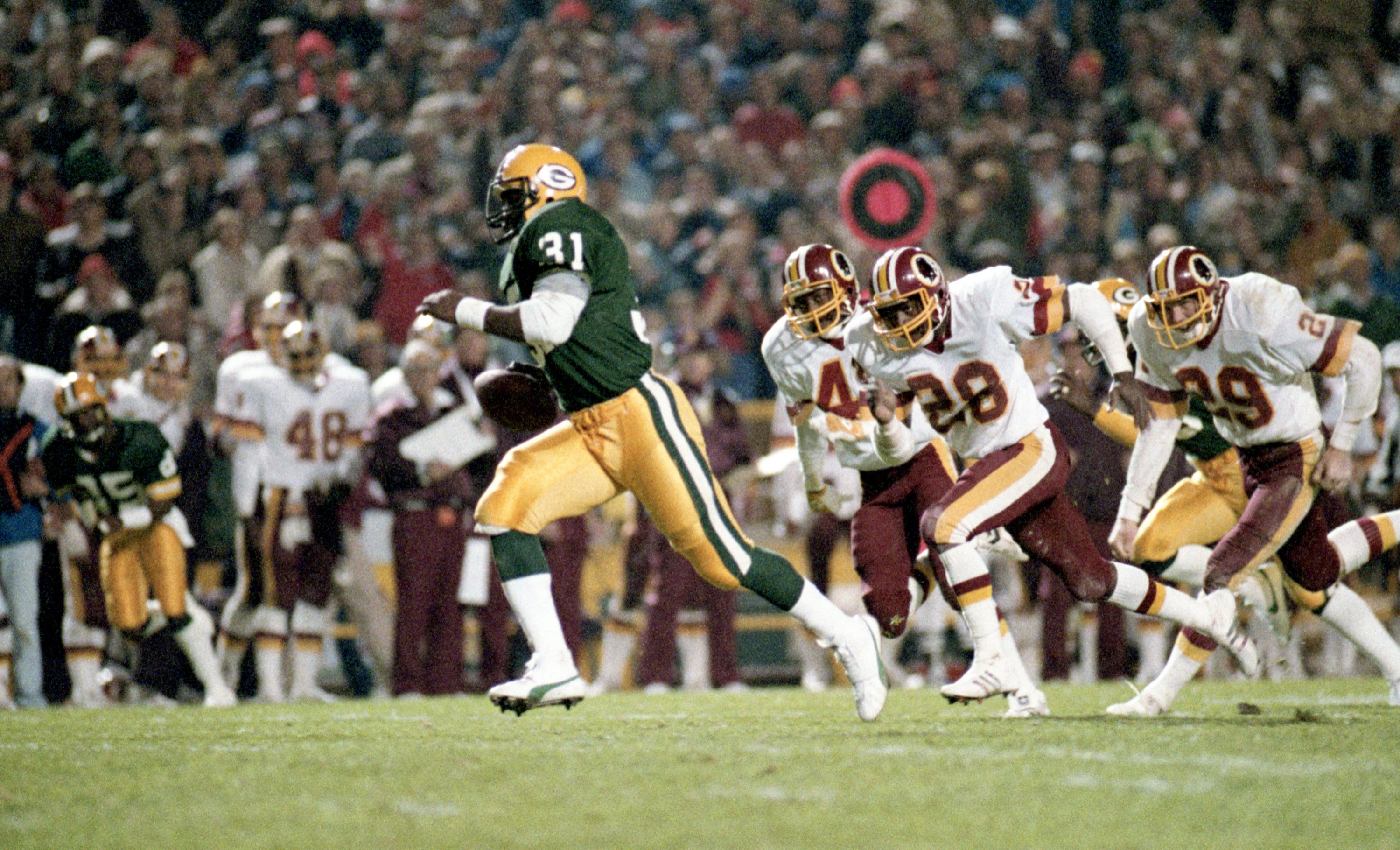 Washington players, including Mark H. Murphy (29), chase Green Bay Packers running back Gerry Ellis (31) on Oct. 17, 1983, at Lambeau Field.