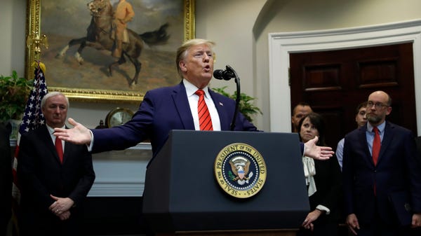 President Donald Trump answers questions from repo